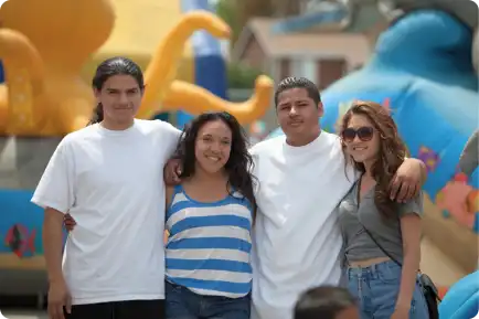 Four teens in a line arms around each other