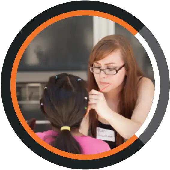 Girl applying make-up to seated girl