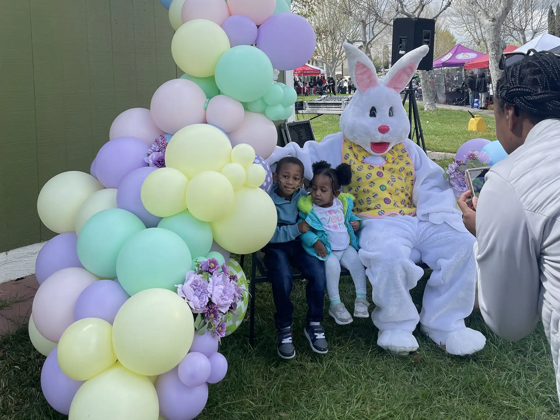 Two young kids with Easter Bunny and balloons